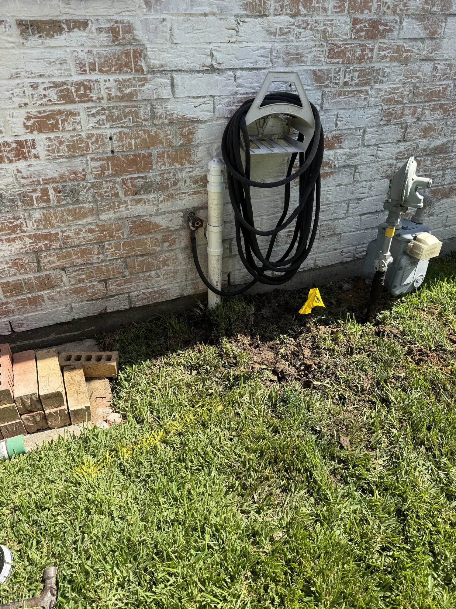 Backfilled excavation at the rerouted drain line beside the gas meter in Port Neches, TX