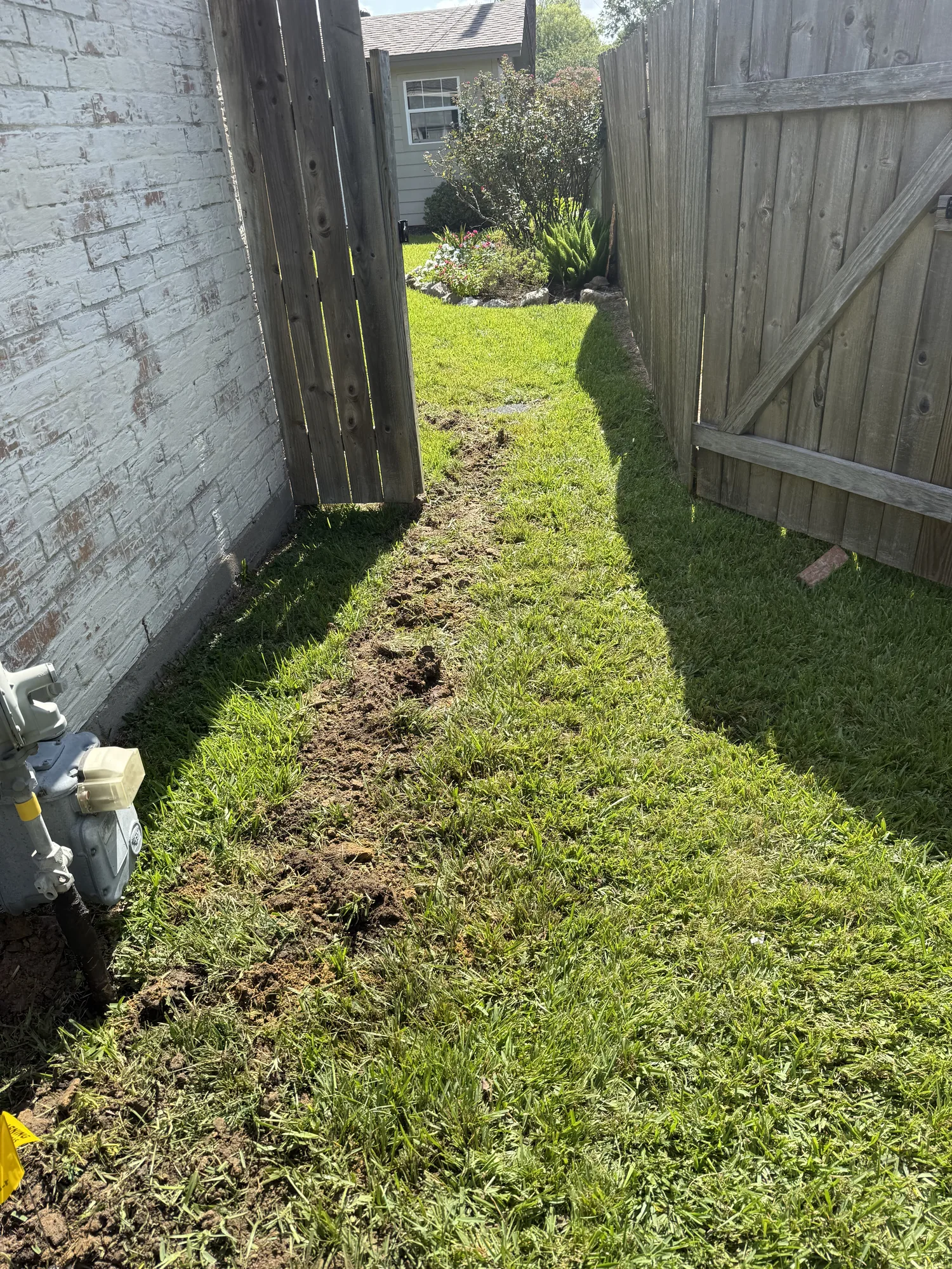 Drain line reroute trench along the side yard in Port Neches, TX
