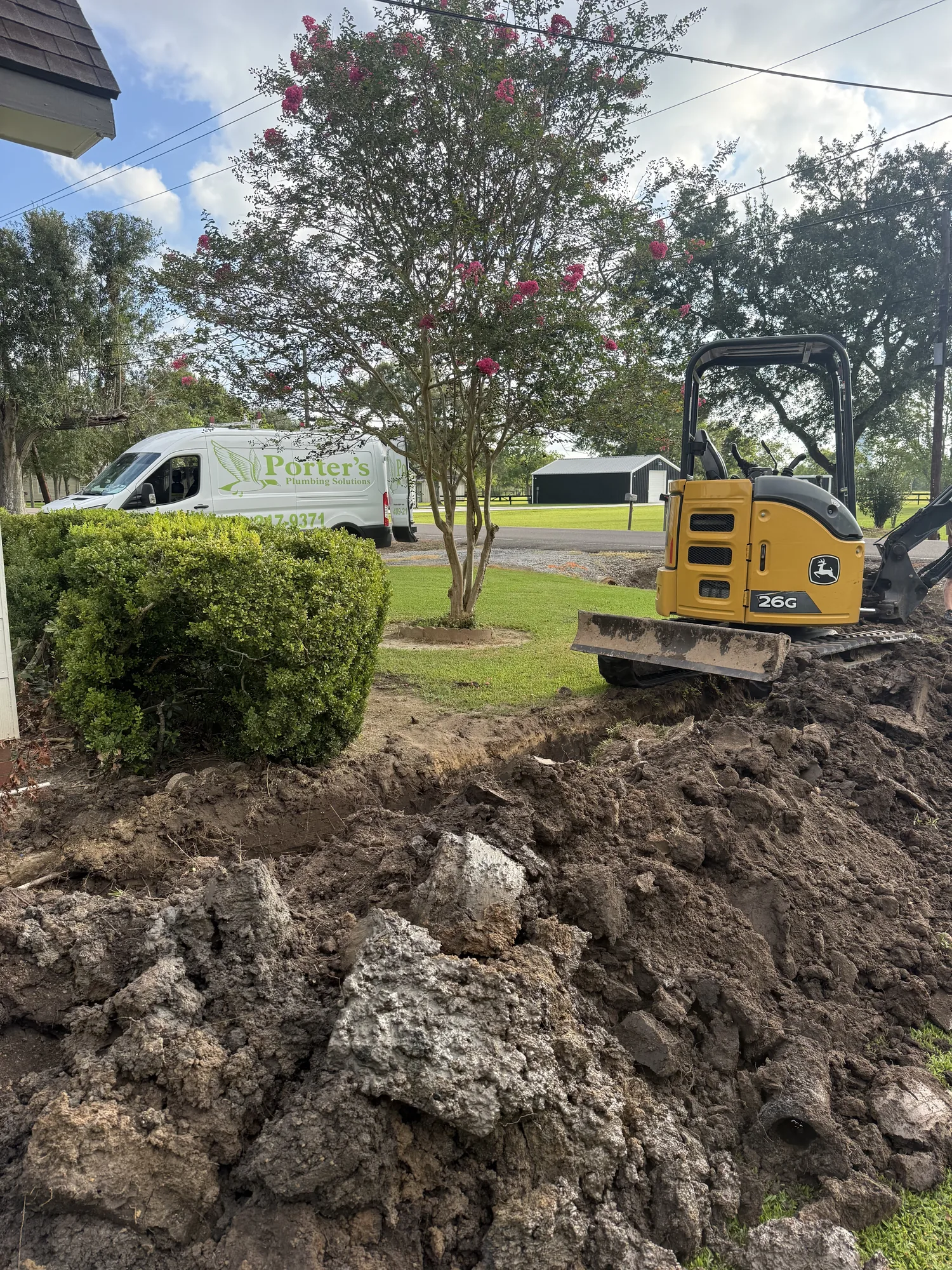 Mini excavator and service van on a sewer line replacement in Port Acres, Port Arthur, TX