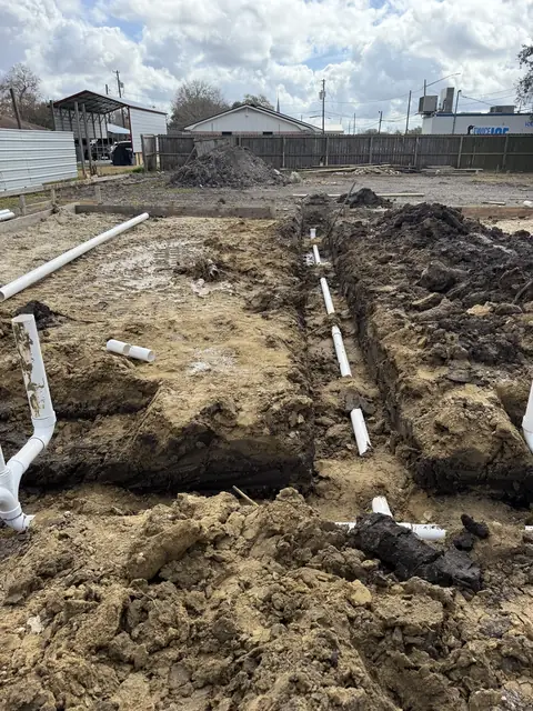 Excavated commercial pad with plumbing rough-in underway in Port Neches, TX
