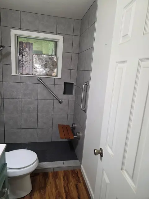 Walk-in shower with grab bars and a fold-down seat in Orange, TX