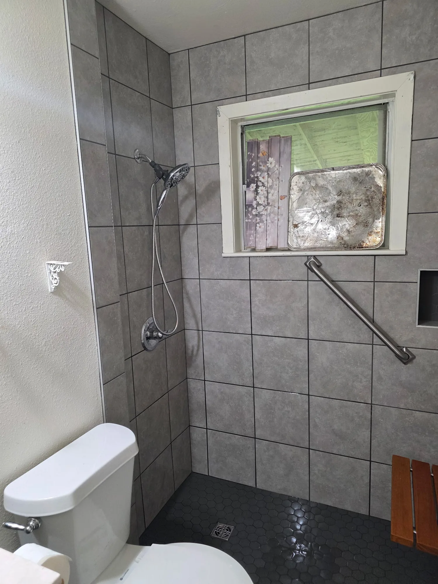Walk-in shower with a handheld shower head and grab bar in Orange, TX